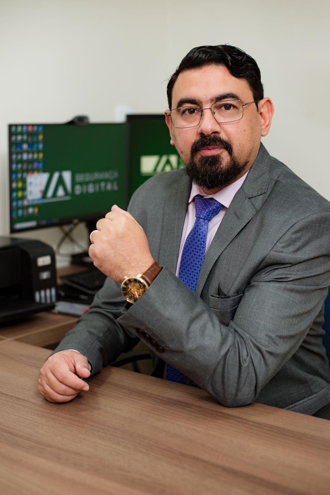 Dr. Marco Aurélio à mesa do escritório, de óculos