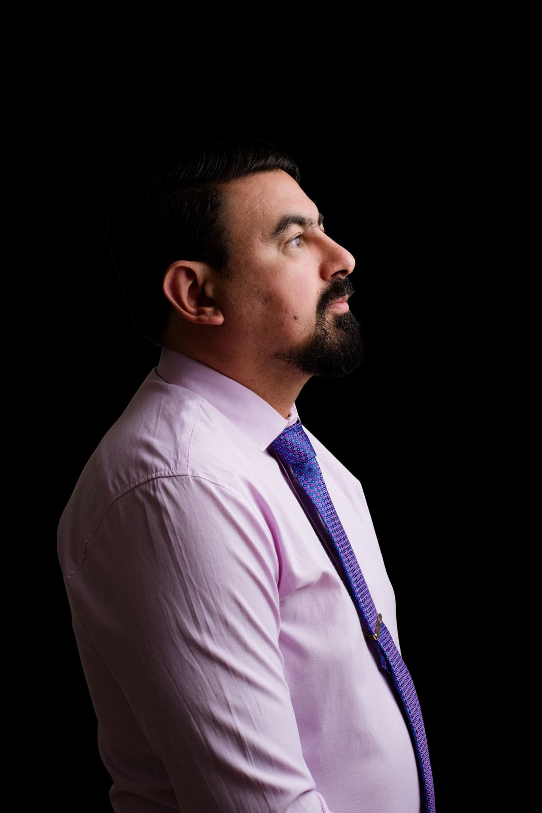 Retrato de perfil do Dr. Marco Aurélio em fundo escuro